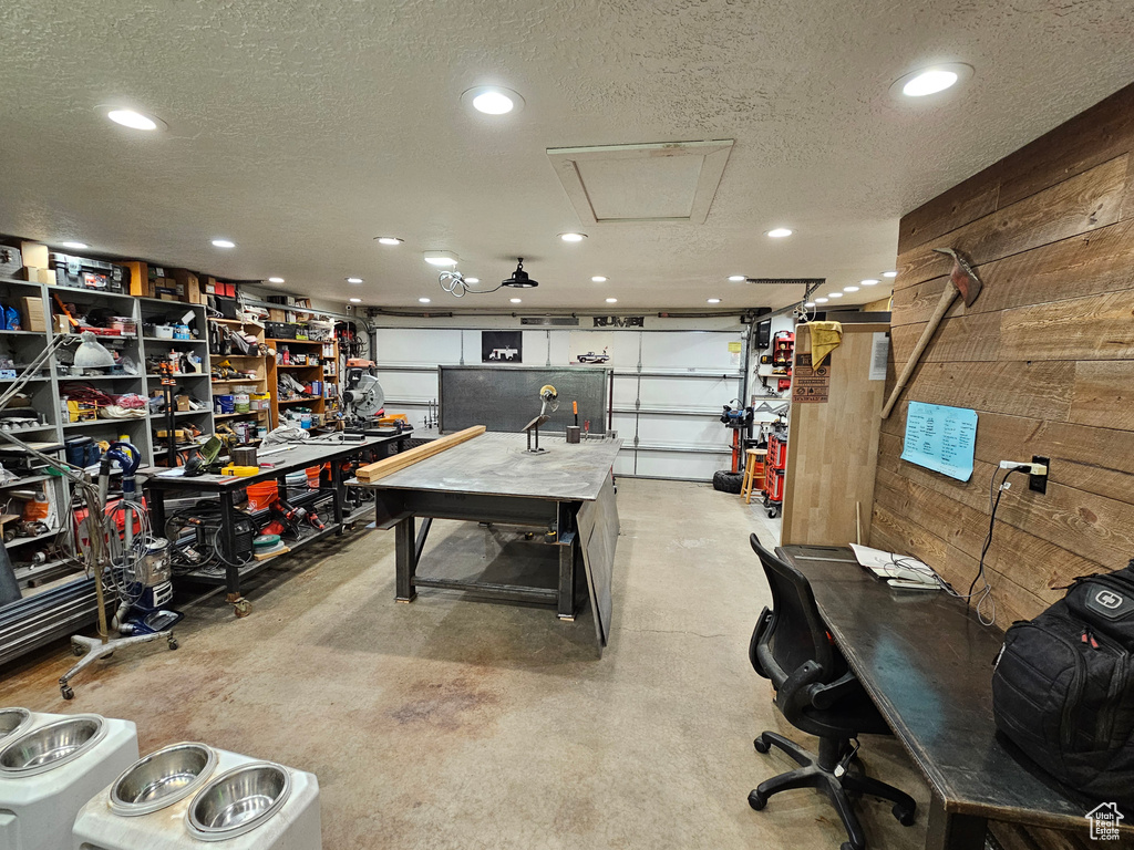 Garage with recessed lighting, cooling unit, and wood walls