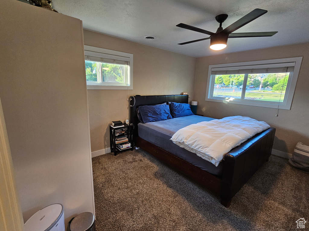 Carpeted bedroom featuring baseboards and a ceiling fan