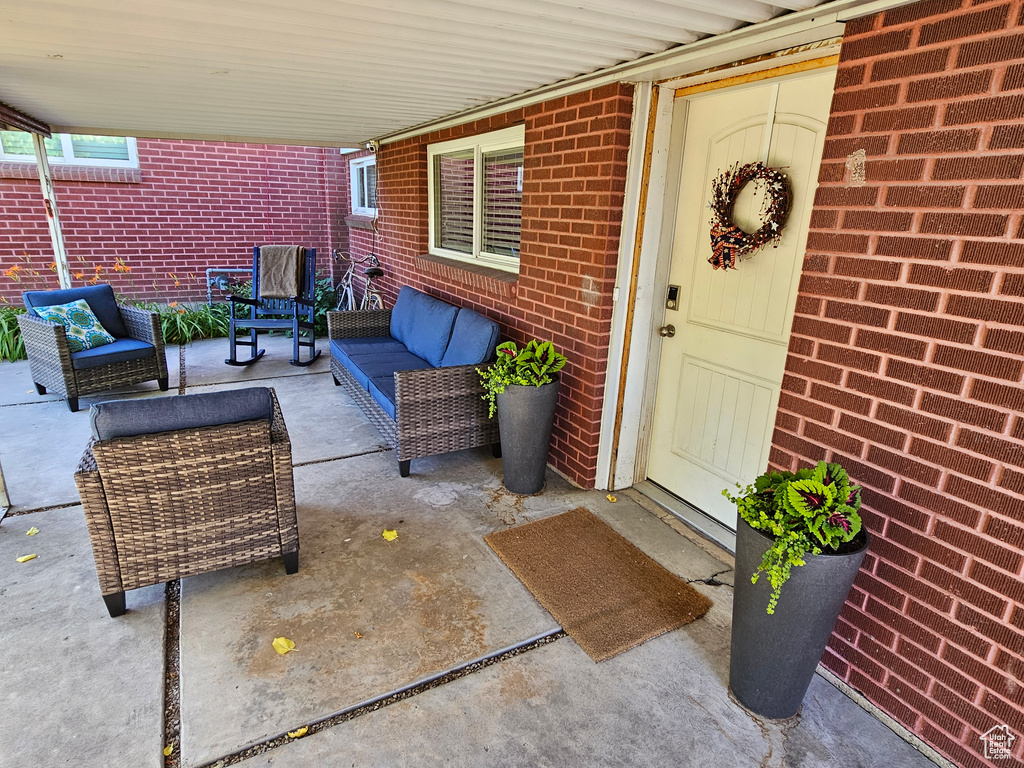 Entrance to property with outdoor lounge area, brick siding, and a patio area