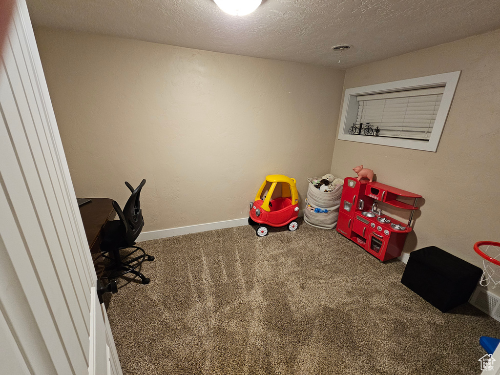 Game room with carpet flooring, a textured ceiling, and baseboards