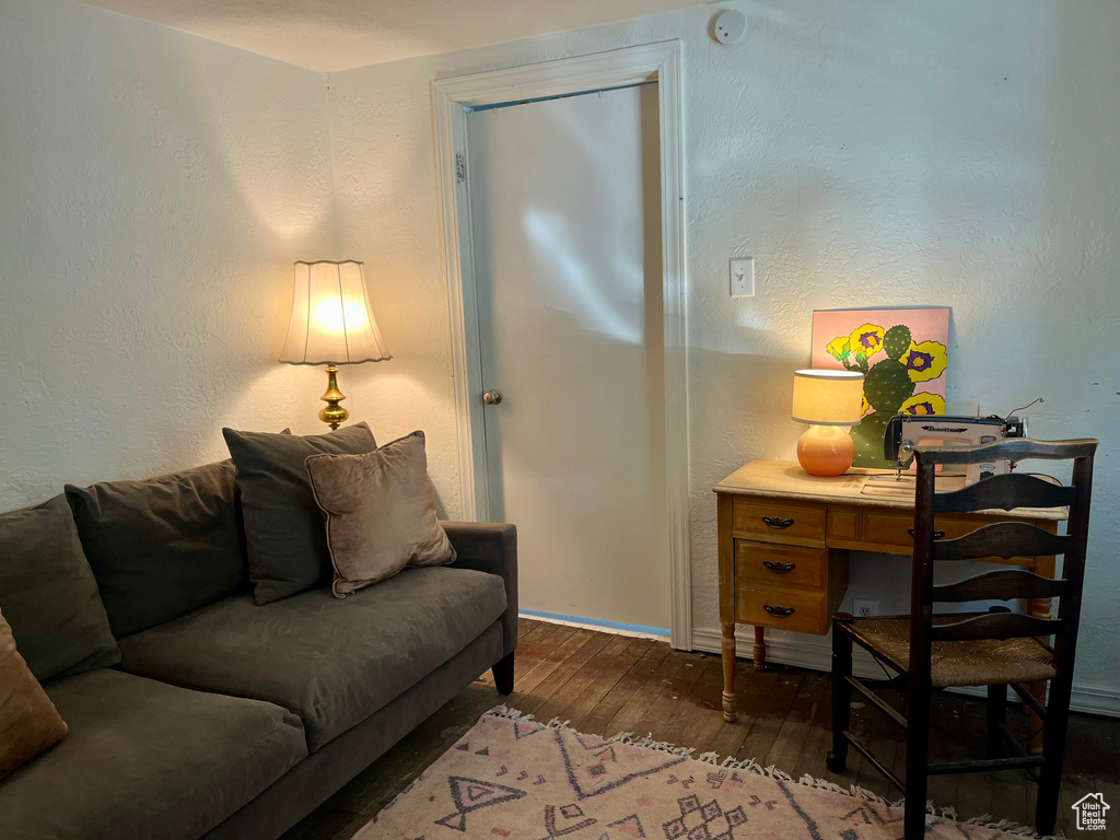 Living room featuring hardwood / wood-style floors, baseboards, and a desk