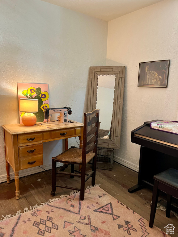Office space featuring wood finished floors, baseboards, and a textured wall