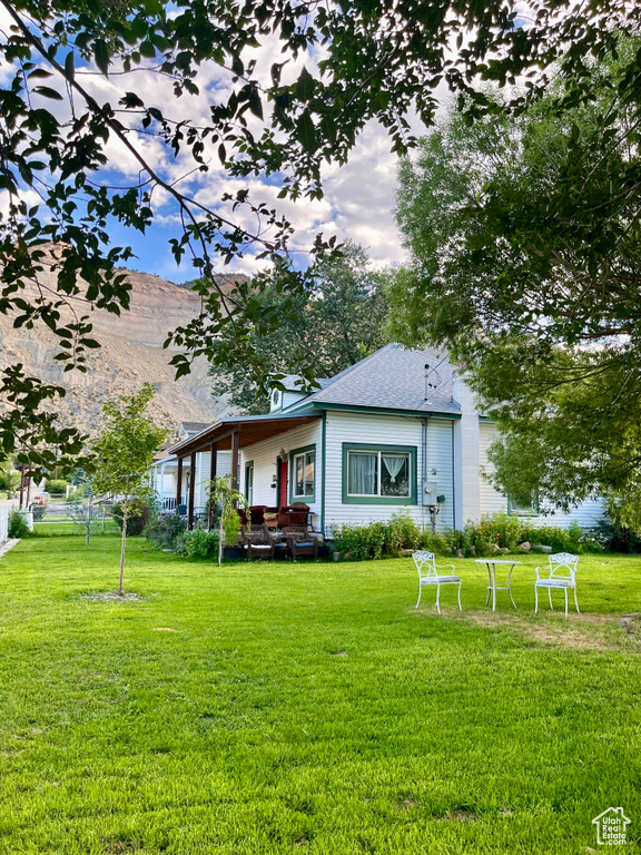 View of front facade with a front lawn, a mountain view, and an outdoor hangout area