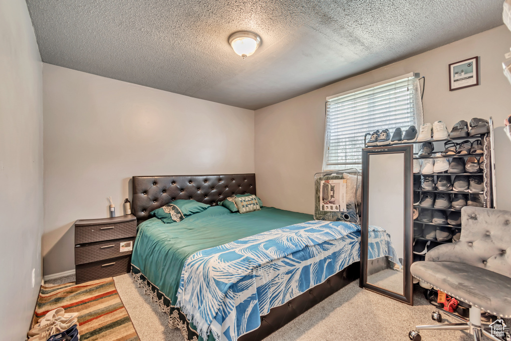 Bedroom featuring a textured ceiling and carpet