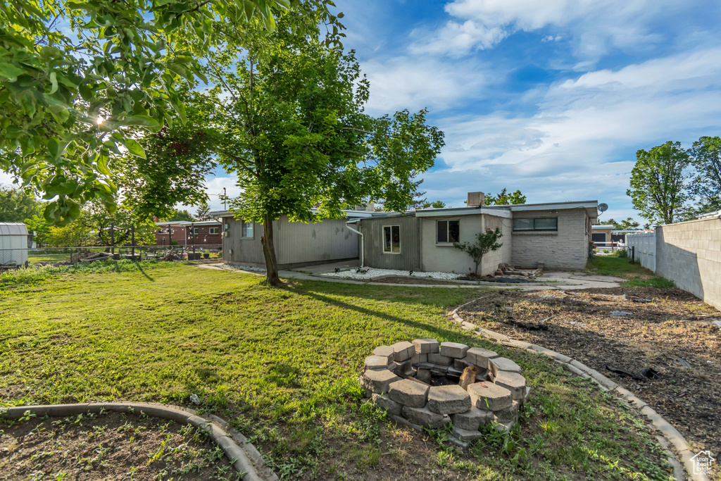 Rear view of property with a fire pit