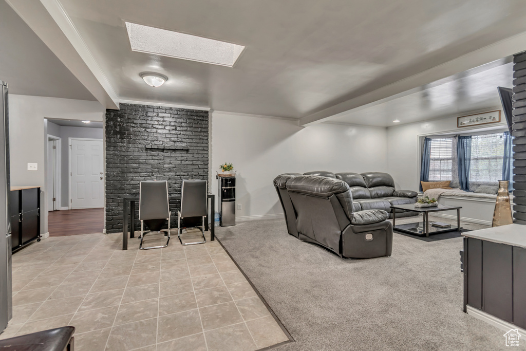 Living area with light tile patterned floors, baseboards, and light colored carpet