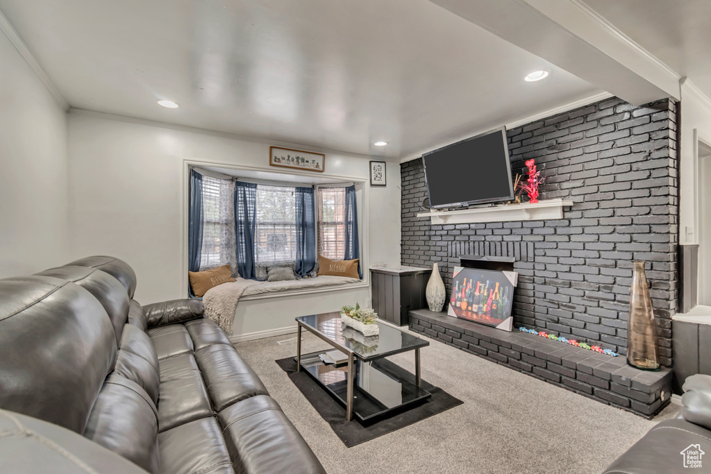 Carpeted living room featuring a fireplace, recessed lighting, and ornamental molding