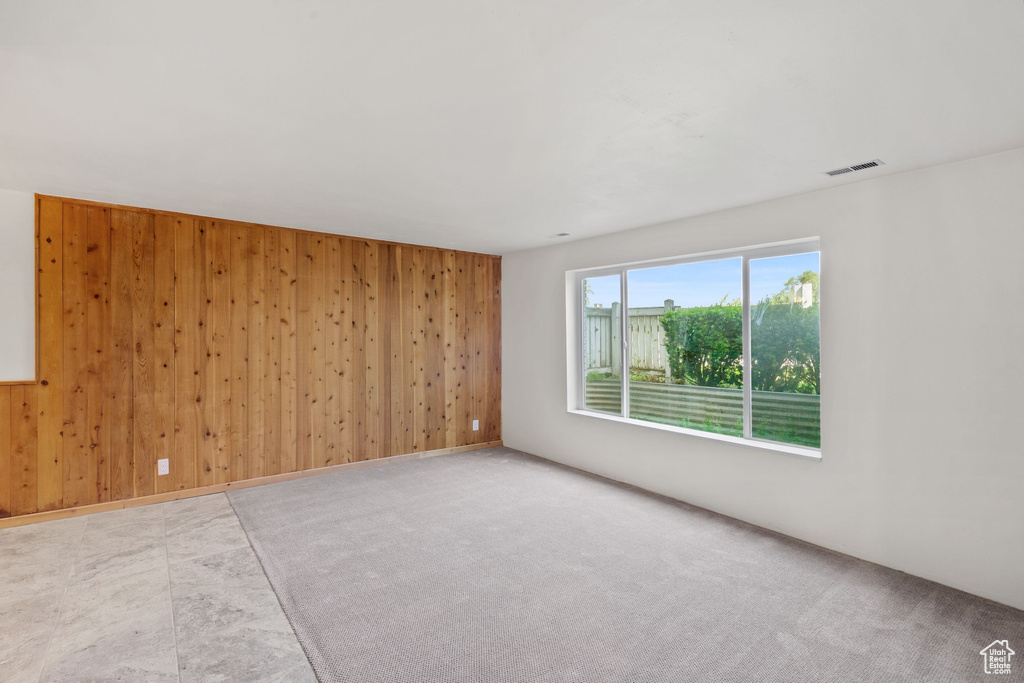 Spare room featuring wooden walls