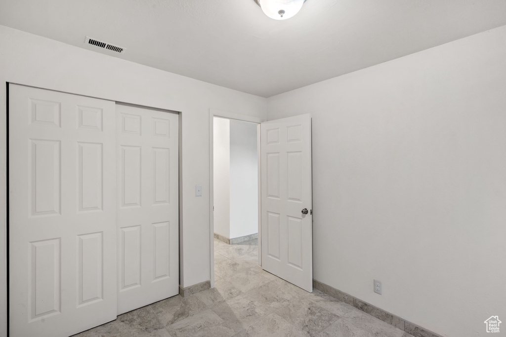 Unfurnished bedroom featuring baseboards and a closet
