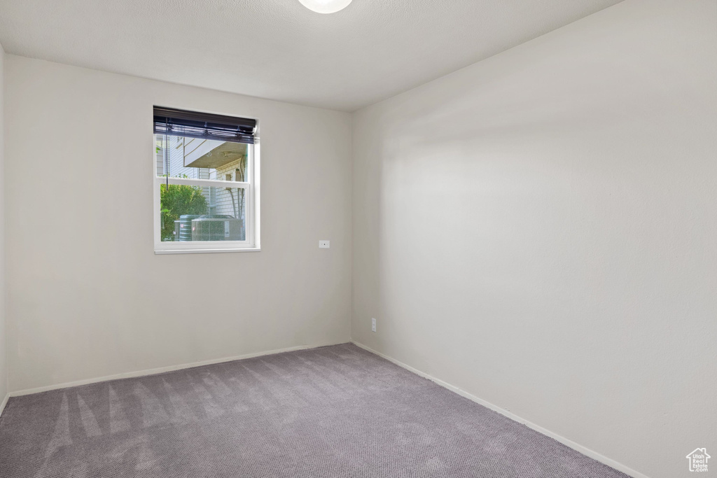 Carpeted spare room with baseboards