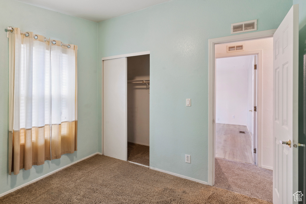 Unfurnished bedroom with carpet flooring and a closet