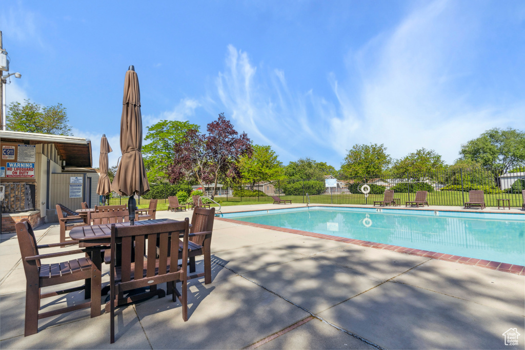 Community pool featuring a patio and outdoor dining area