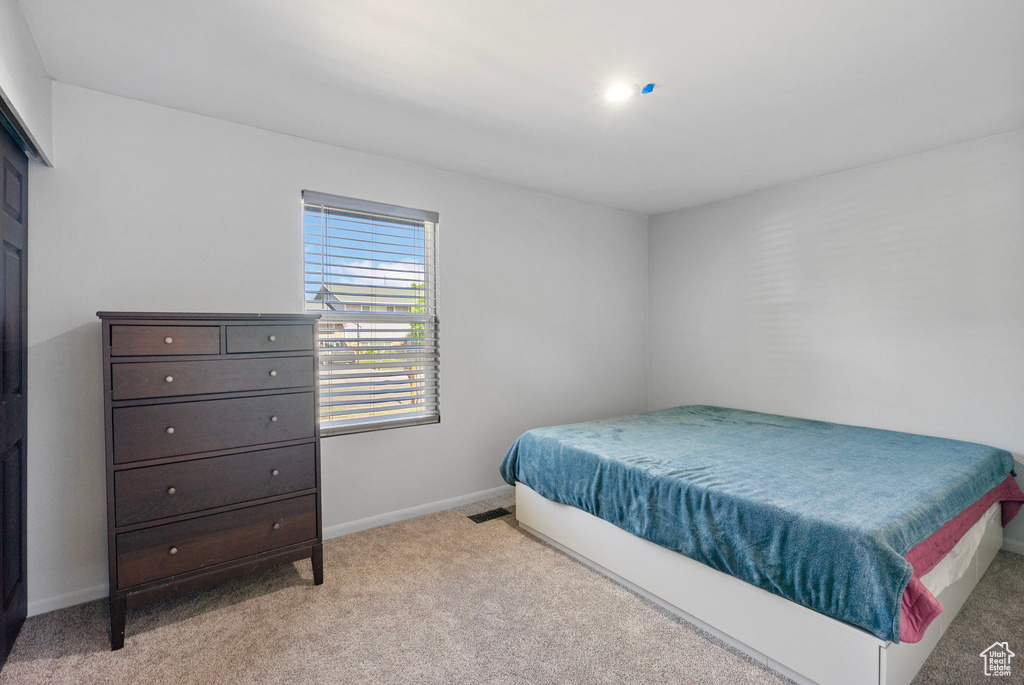 Bedroom featuring light colored carpet and baseboards