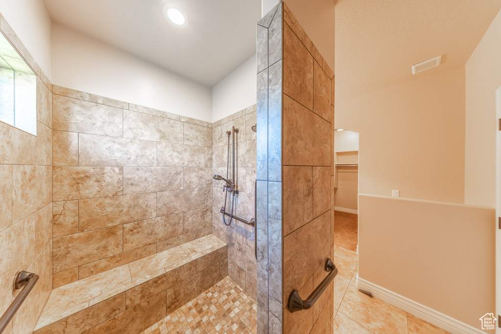 Full bath with tiled shower, tile patterned floors, a walk in closet, and recessed lighting