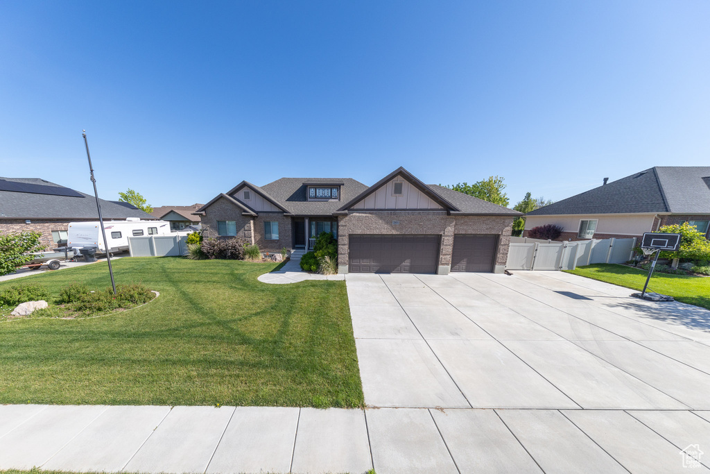 View of front of property with a garage, concrete driveway, board and batten siding, brick siding, and a residential view