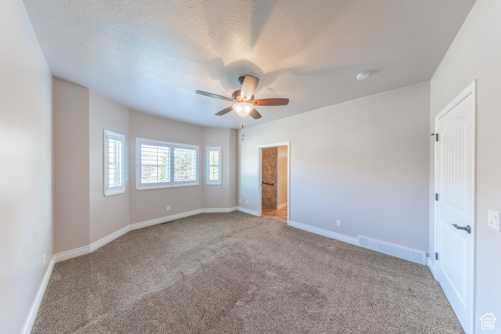 Unfurnished bedroom with carpet, baseboards, ceiling fan, and a textured ceiling