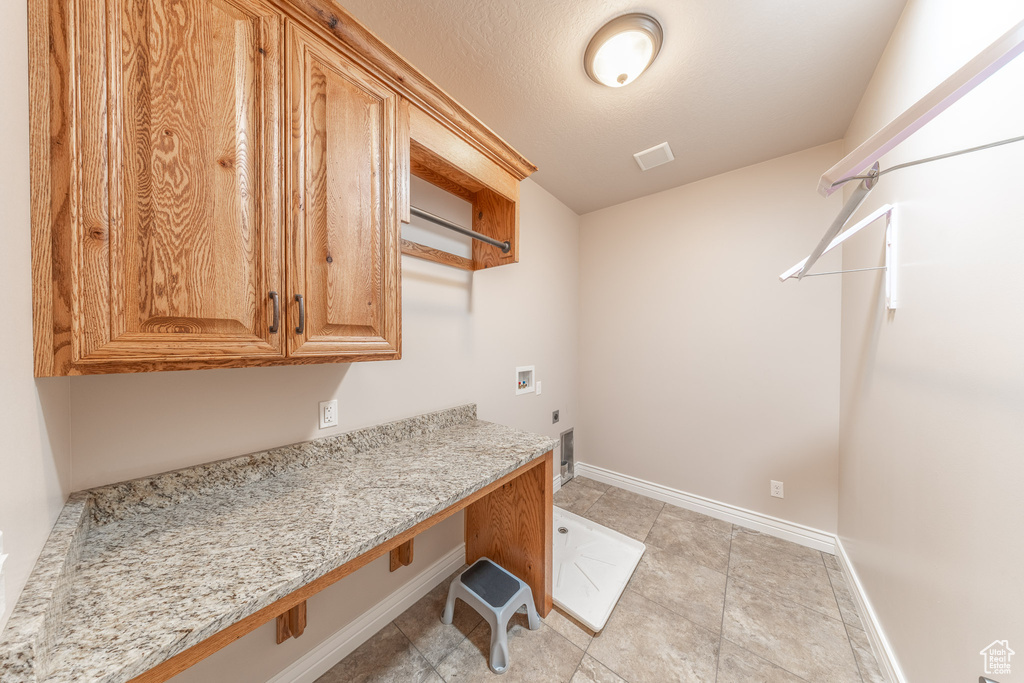 Laundry room featuring electric dryer hookup, hookup for a washing machine, cabinet space, baseboards, and an office area