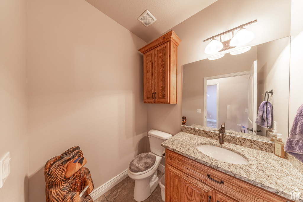Half bathroom featuring toilet, vanity, baseboards, and lofted ceiling
