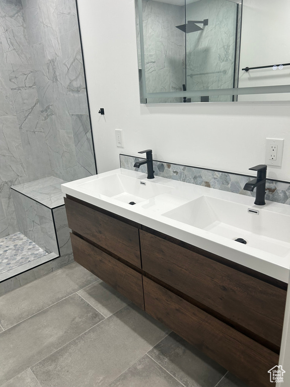 Bathroom featuring double vanity and a marble finish shower