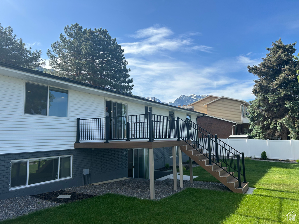 Rear view of property featuring stairway and a wooden deck