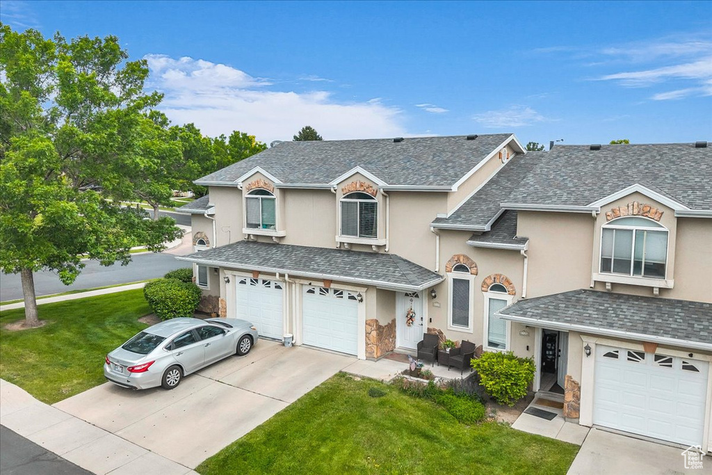 Traditional-style house with a garage, stucco siding, concrete driveway, and stone siding