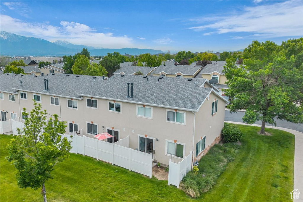 Rear view of house with stucco siding, a mountain view, roof with shingles, and a residential view