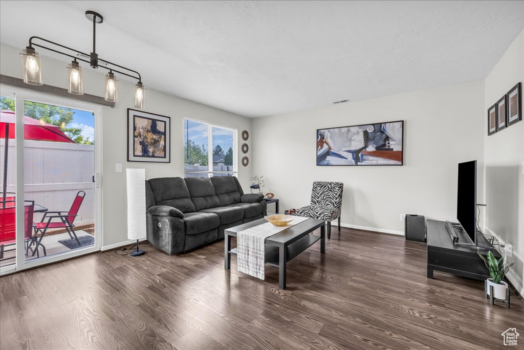 Living room with wood finished floors, healthy amount of natural light, and baseboards
