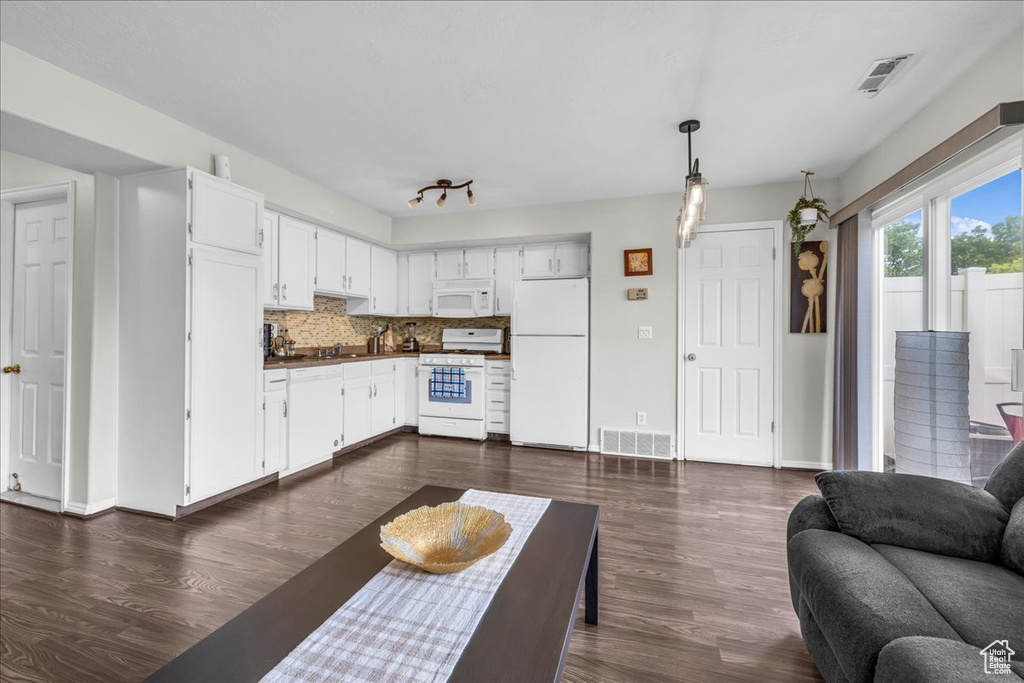 Living room featuring dark wood-type flooring and baseboards