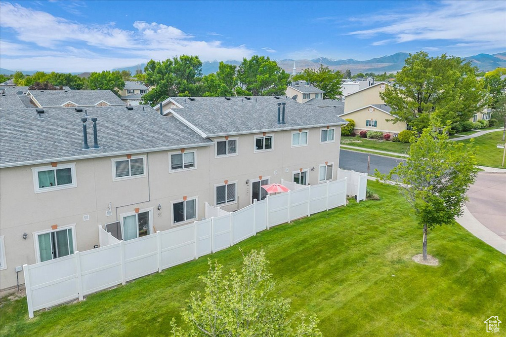 Back of property featuring roof with shingles, a mountain view, a residential view, and stucco siding