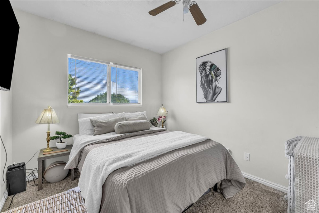 Carpeted bedroom with baseboards and a ceiling fan