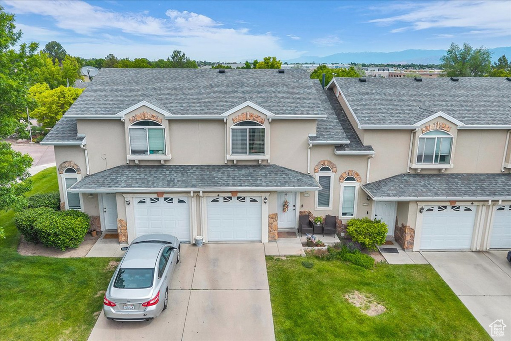 Traditional-style house with stucco siding, concrete driveway, an attached garage, and stone siding