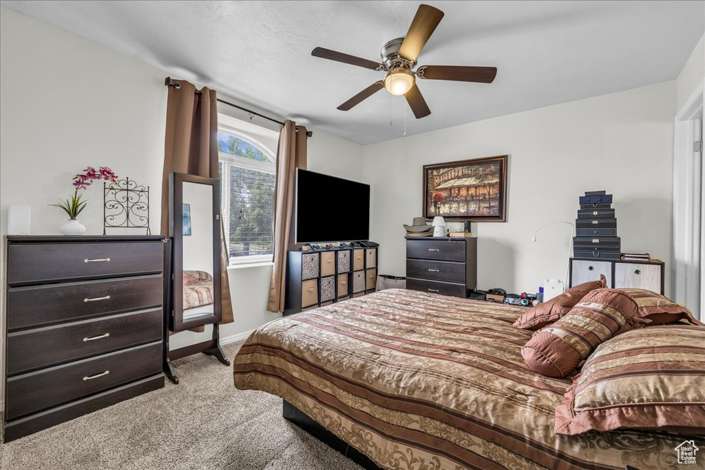 Carpeted bedroom with baseboards and ceiling fan