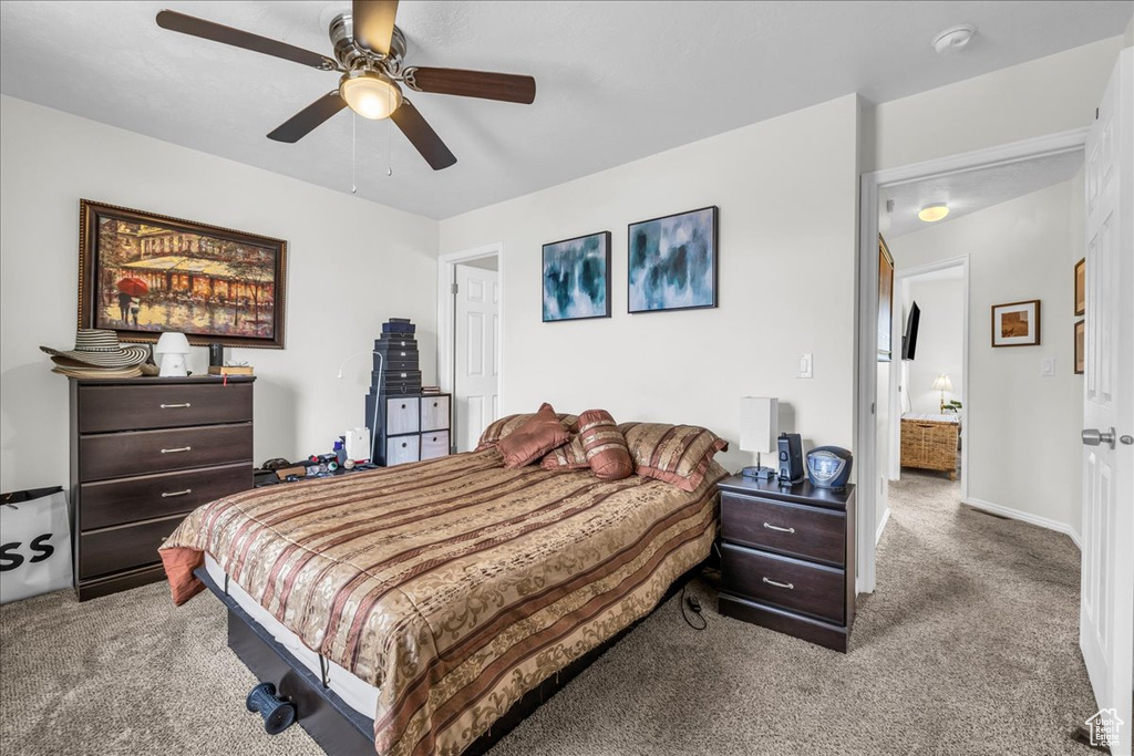 Carpeted bedroom featuring ceiling fan