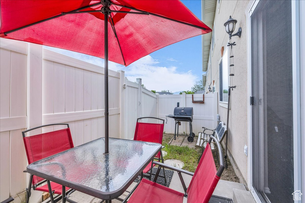 Fenced backyard with area for grilling, outdoor dining area, and a patio