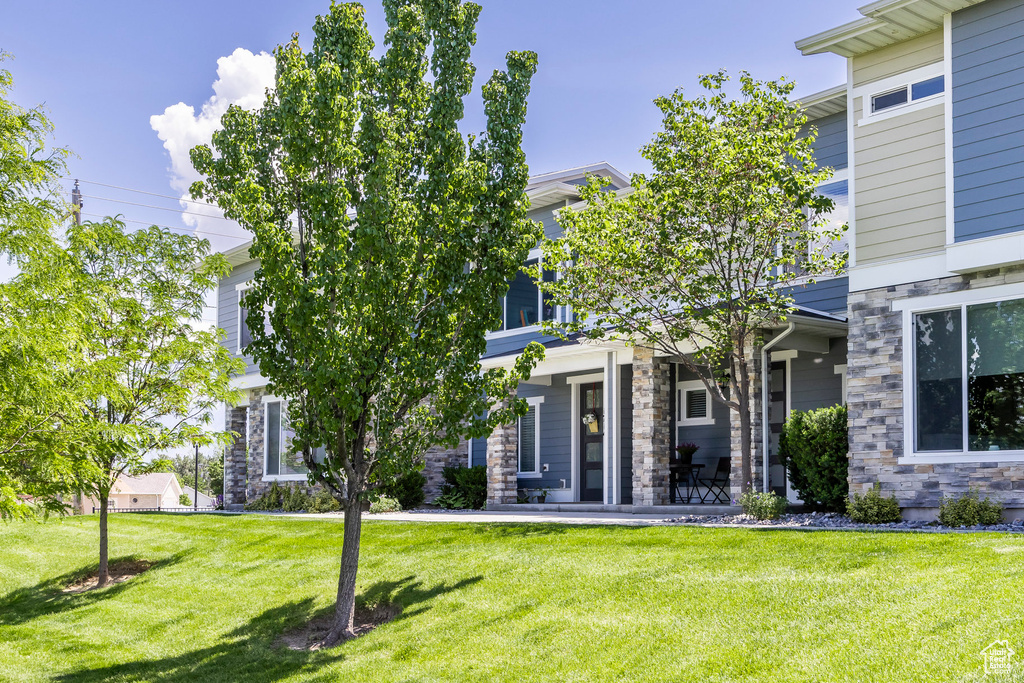 View of front of home with a front yard and stone siding