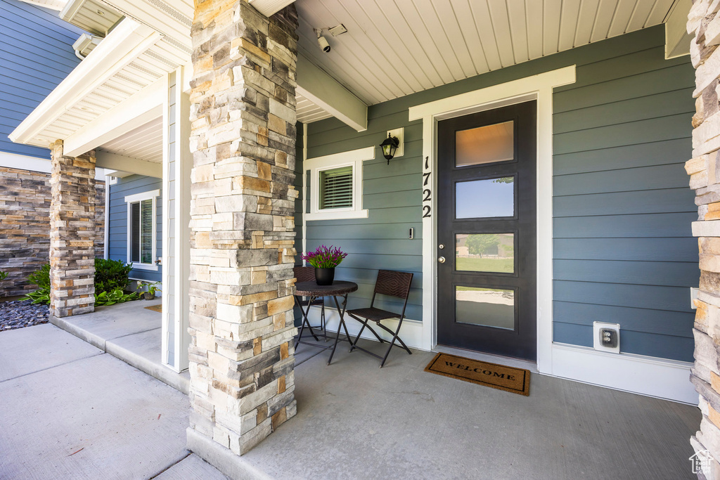 Entrance to property featuring a porch and stone siding