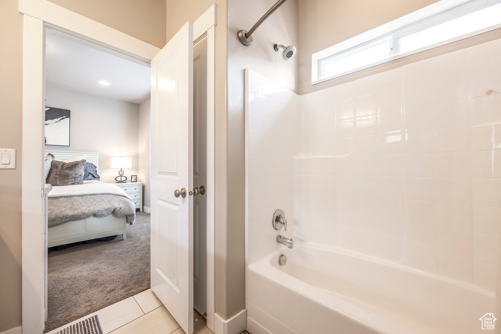 Full bath with ensuite bathroom, shower / bath combination, and tile patterned floors