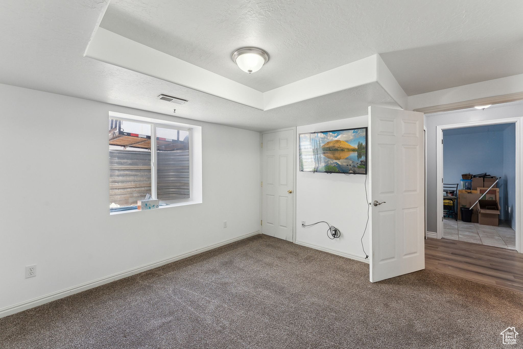 Unfurnished bedroom with carpet flooring, baseboards, and a textured ceiling