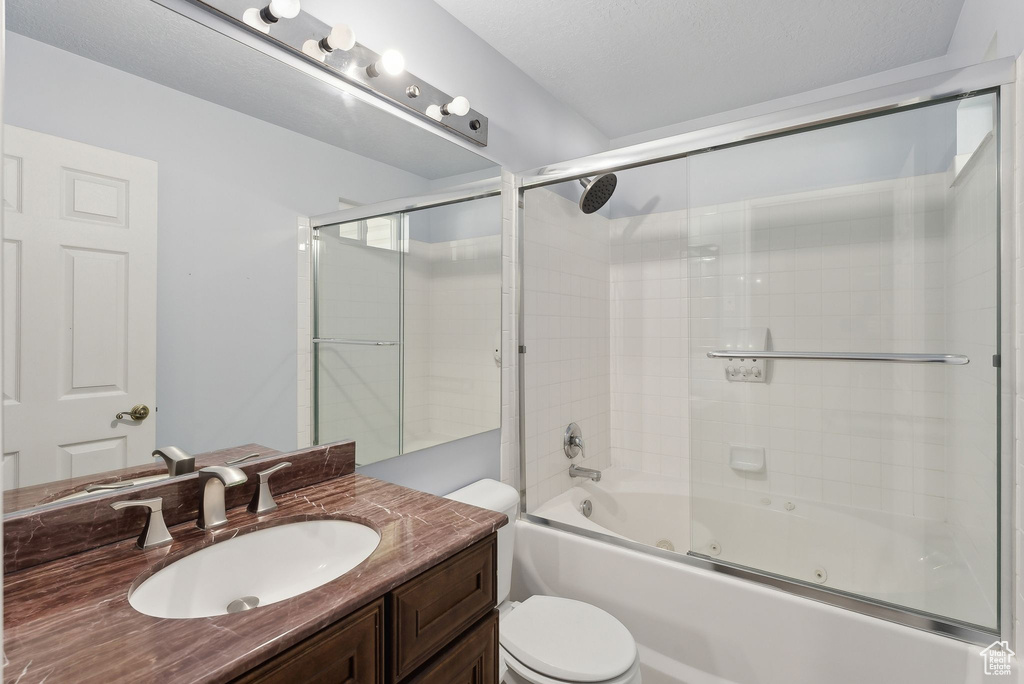 Bathroom featuring toilet, vanity, and a combined bath / shower with jetted tub
