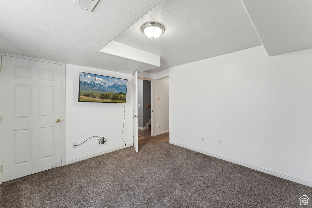 Unfurnished bedroom featuring carpet floors, baseboards, and a textured ceiling