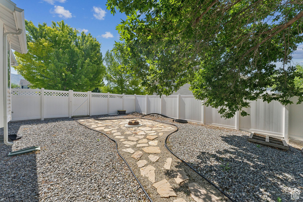 Fenced backyard with an outdoor fire pit and a patio