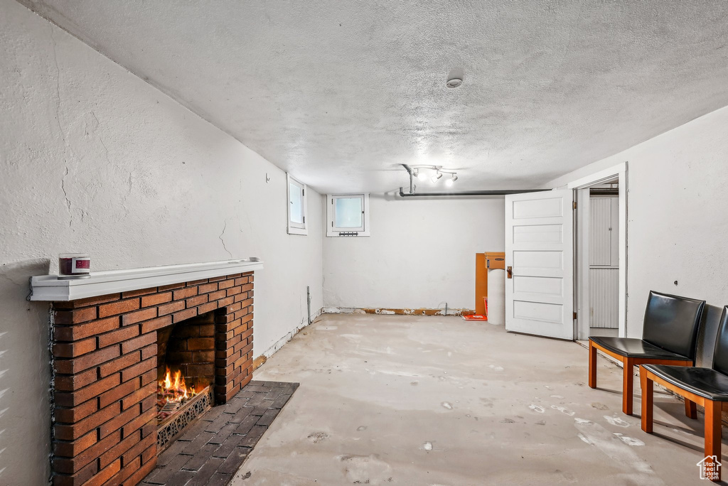 Basement with a brick fireplace and a textured ceiling