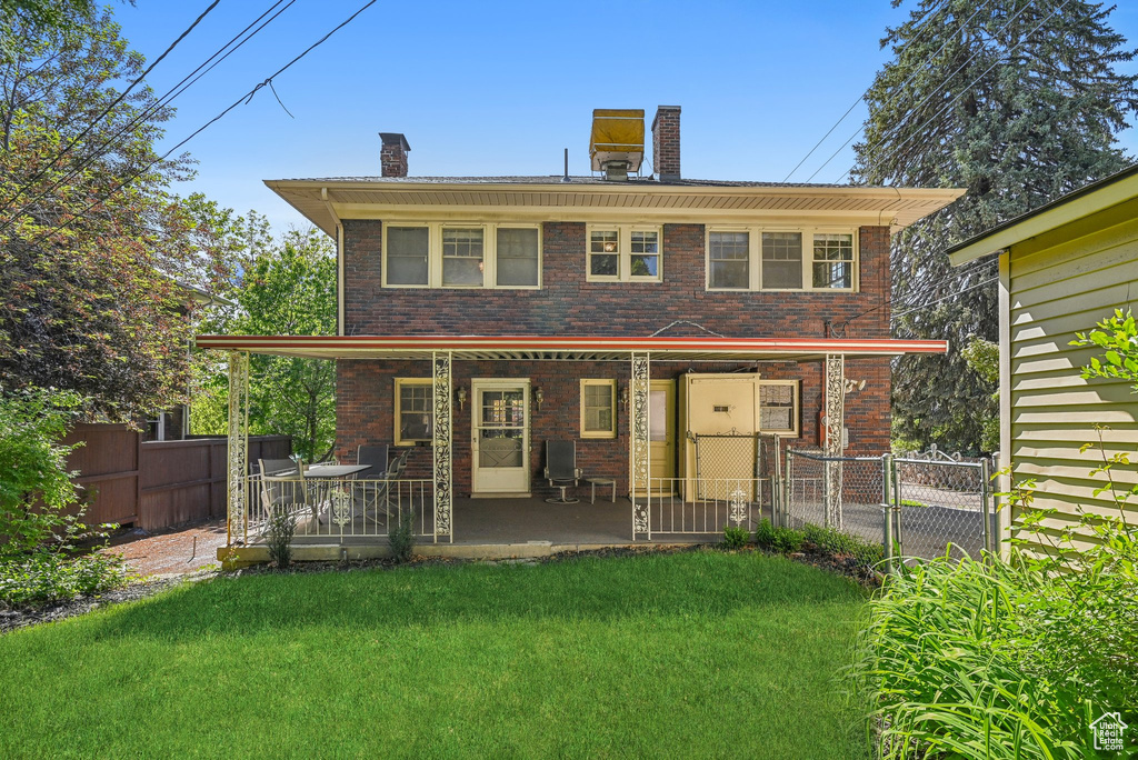 Back of property with a chimney and brick siding