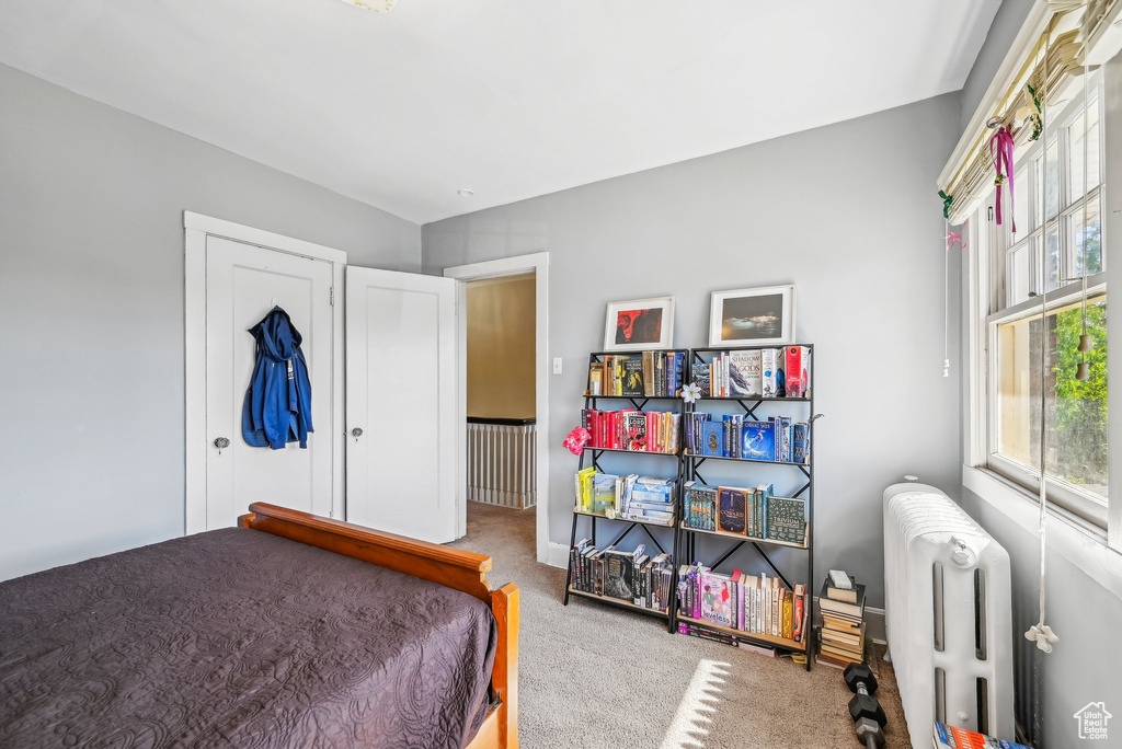 Bedroom featuring radiator heating unit and carpet