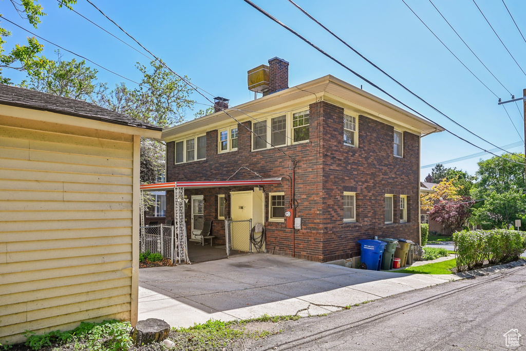 Rear view of house with a chimney and brick siding