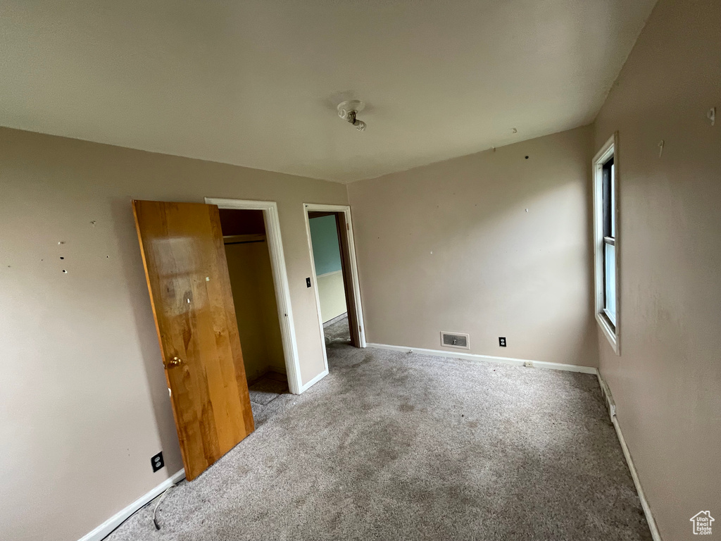 Unfurnished bedroom featuring carpet and baseboards