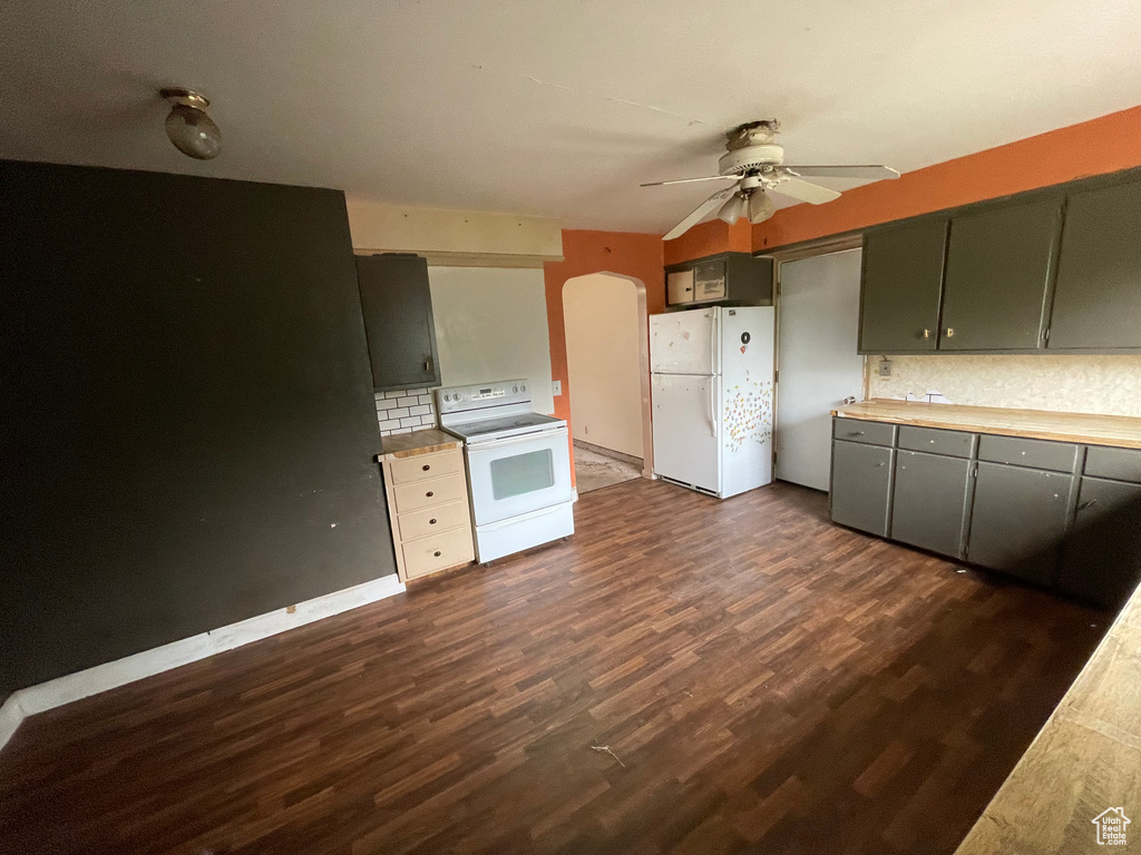 Kitchen with white appliances, arched walkways, a ceiling fan, tasteful backsplash, and light countertops