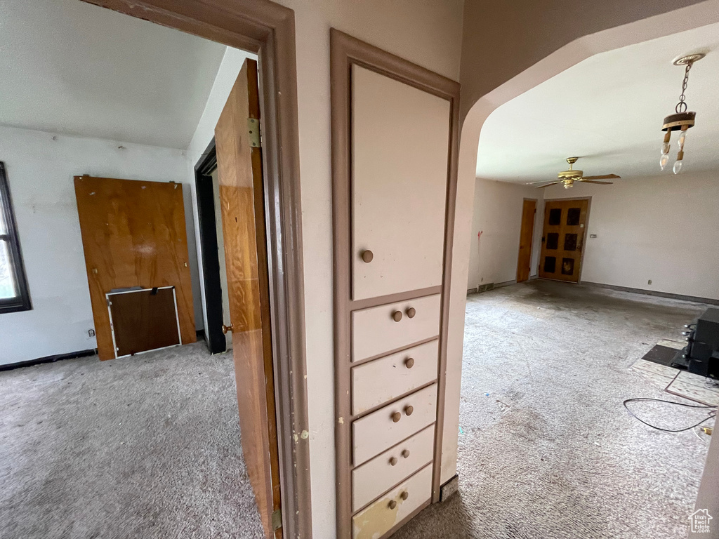 Hallway with carpet flooring, arched walkways, and baseboards