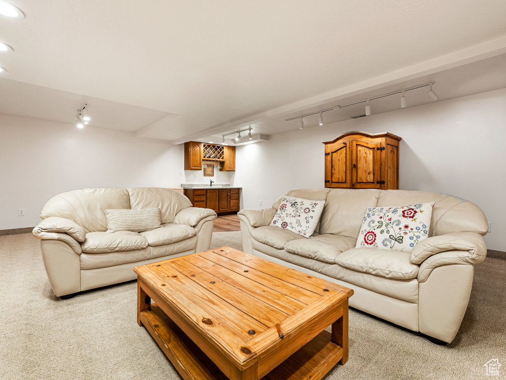 Living area featuring track lighting, light carpet, and bar area