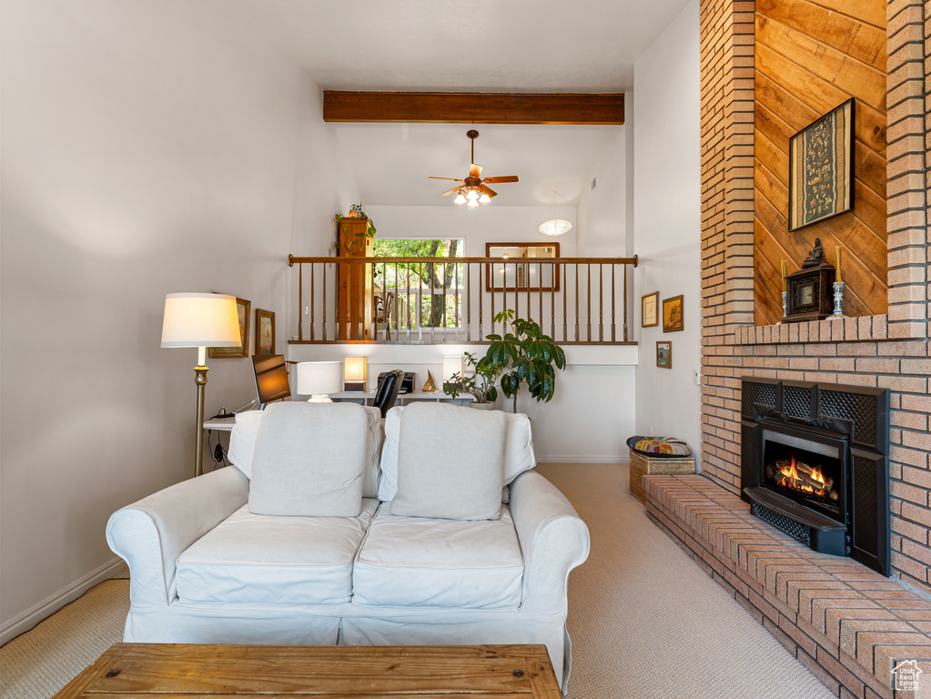 Living area featuring carpet floors, ceiling fan, a brick fireplace, and baseboards